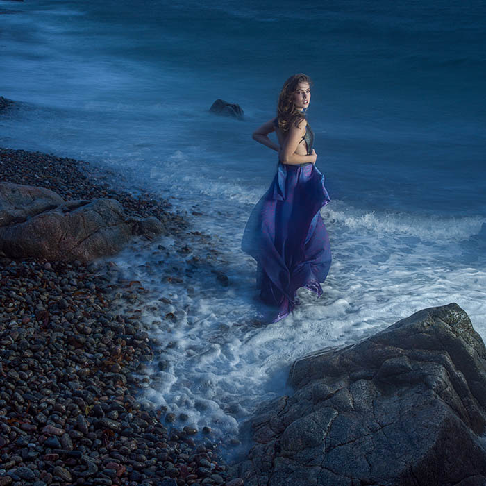 Model standing in stormy ocean