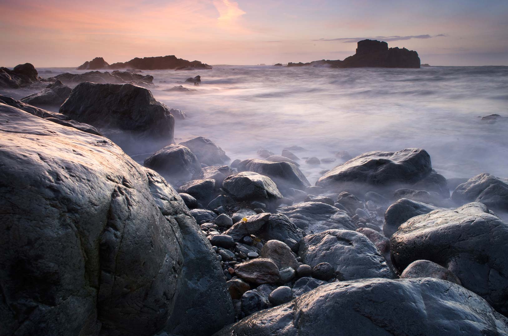 Seascape landscape image with rocks in the foreground